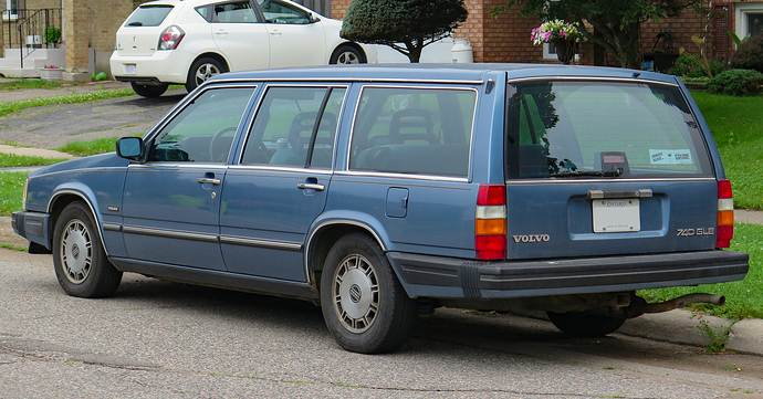 1986_Volvo_740_GLE_Wagon_in_Medium_Blue_Metallic,_rear_left,_2024-07-15